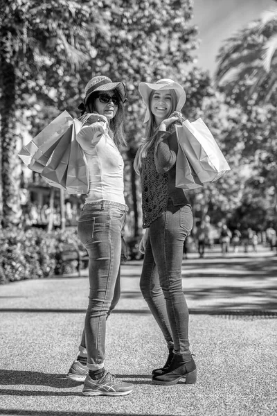 2人の美しい女性のショッピング 藁帽子とバッグ付きの幸せなリラックスした表情屋外 — ストック写真