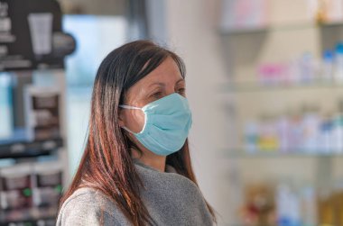 Yerel eczanede maske takan bir kadın..
