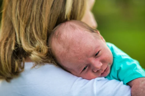 母親に世話をされながら街の公園で生まれたばかりの赤ん坊の屋外 — ストック写真