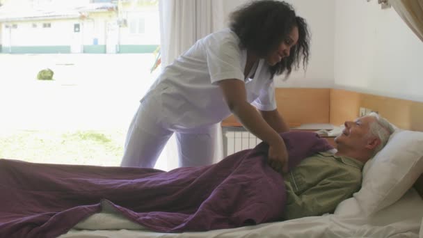 Zpomalený pohyb asijského lékaře, který pomáhá starším důchodcům jít do nemocniční postele. Koncept štěstí, rehabilitace a odchodu do důchodu