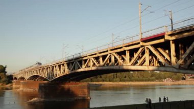 yağmur demiryolu köprüsünde tarafından geçer. demir yolu Köprüsü, nehrin üzerinde duruyor. Mavi gökyüzü temizleyin. Köprü üzerinde bir nehirdir. Köprü geçişleri bir tren yeşildir. Yolcu treni.