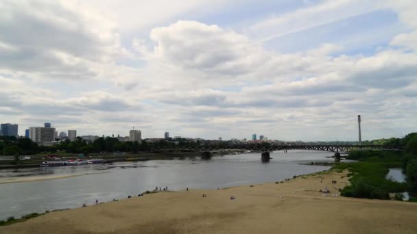 De brug over de rivier. bruggen Warschau. Time-lapse van de Poniatowski brug in Warschau, Polen. Zomer, zonnige dag, de rivier, de brug met de trein, de oude stad. groene bomen — Stockvideo