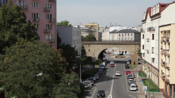 Varsovie Pont de passage à niveau dans la ville. La vie dépend d'un jour de semaine avec passage à niveau de métro surélevé. Beaucoup de voitures et de navetteurs. Activités humaines dans les rues de Varsovie. Le train rouge traverse le passage à niveau, entre les maisons — Video