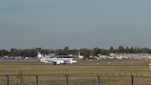 商業飛行機はワルシャワ空港で離陸。空港で旅客機が離陸滑走路を残してジェット飛行機を飛んでします。航空機が滑走路を離れる — ストック動画