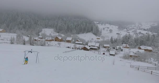 Zimowy krajobraz górski we wsi. Lotu z wysokości powyżej Domy drewniane pokryte śniegiem. Wieś w zimie. Seul od ptaka w zimie. — Wideo stockowe
