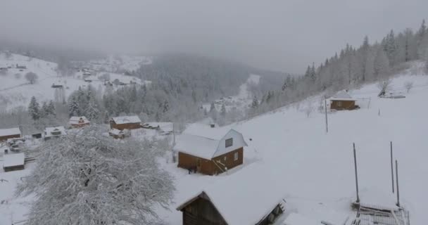 冬山风景在村子里。从以上白雪覆盖的木制房屋的高度飞行。冬天的村庄。从冬天的鸟瞰首尔. — 图库视频影像