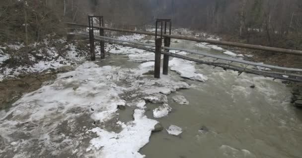 Rio de montanha da vista de um pássaro, inverno nevado. Voa sobre o rio nas montanhas. Paisagem de montanha de inverno da vista de um pássaro. Rápido rio de montanha na neve . — Vídeo de Stock