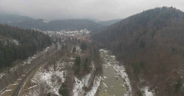 Гірська річка від Пташине око зору, сніжні зими. Мух над річкою в горах. Зимовий гірський краєвид з висоти пташиного очей. Швидкий гірська річка на снігу. — стокове відео