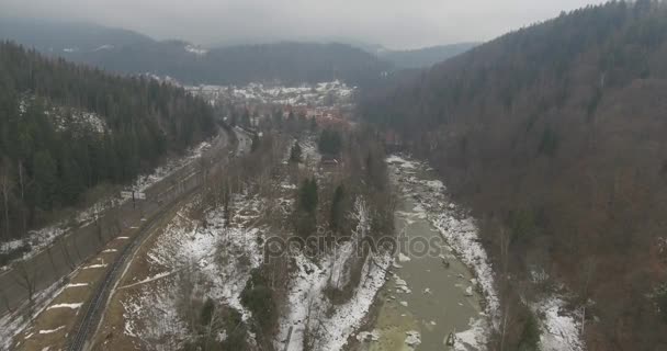 Гірська річка від Пташине око зору, сніжні зими. Мух над річкою в горах. Зимовий гірський краєвид з висоти пташиного очей. Швидкий гірська річка на снігу. — стокове відео