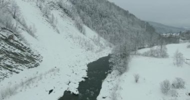 Kış dağlarda. Uçuş kış manzara Dağların üzerinden. Karlı kış dağlarda. Bulutlu kış günü. Dağ manzarası üzerinden bir kuş bakışı.