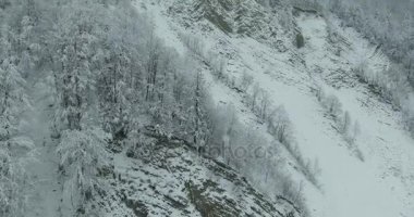 Kış dağlarda. Uçuş kış manzara Dağların üzerinden. Karlı kış dağlarda. Bulutlu kış günü. Dağ manzarası üzerinden bir kuş bakışı.