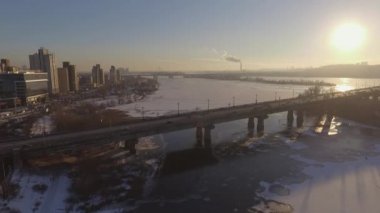 Kiev. Ukrayna. Dinyeper Nehri kış köprüden. Şehri kuşbakışı, gün batımı Lonza ile yayılır. Kiev şehir Dinyeper Nehri üzerinde olduğunu. Kiev batımında Dnieper Nehri üzerinde uçan. Daire binaların çatıları 