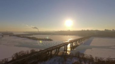Kiev. Ukrayna. Dinyeper Nehri kış köprüden. Şehri kuşbakışı, gün batımı Lonza ile yayılır. Kiev şehir Dinyeper Nehri üzerinde olduğunu. Kiev batımında Dnieper Nehri üzerinde uçan. Daire binaların çatıları