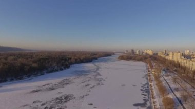 Kiev. Ukrayna. Dinyeper Nehri kış köprüden. Şehri kuşbakışı, gün batımı Lonza ile yayılır. Kiev şehir Dinyeper Nehri üzerinde olduğunu. Kiev batımında Dnieper Nehri üzerinde uçan. Daire binaların çatıları 