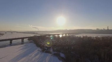 Kiev. Ukrayna. Dinyeper Nehri kış köprüden. Şehri kuşbakışı, gün batımı Lonza ile yayılır. Kiev şehir Dinyeper Nehri üzerinde olduğunu. Kiev batımında Dnieper Nehri üzerinde uçan. Daire binaların çatıları