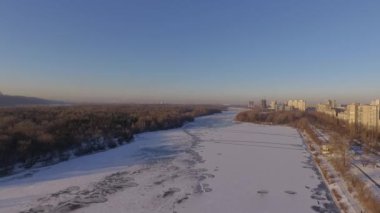 Kiev. Ukrayna. Dinyeper Nehri kış köprüden. Şehri kuşbakışı, gün batımı Lonza ile yayılır. Kiev şehir Dinyeper Nehri üzerinde olduğunu. Kiev batımında Dnieper Nehri üzerinde uçan. Daire binaların çatıları 