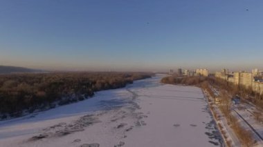 Kiev. Ukrayna. Dinyeper Nehri kış köprüden. Şehri kuşbakışı, gün batımı Lonza ile yayılır. Kiev şehir Dinyeper Nehri üzerinde olduğunu. Kiev batımında Dnieper Nehri üzerinde uçan. Daire binaların çatıları 