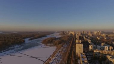 Kiev. Ukrayna. Dinyeper Nehri kış köprüden. Şehri kuşbakışı, gün batımı Lonza ile yayılır. Kiev şehir Dinyeper Nehri üzerinde olduğunu. Kiev batımında Dnieper Nehri üzerinde uçan. Daire binaların çatıları 