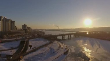 Kiev. Ukrayna. Dinyeper Nehri kış köprüden. Şehri kuşbakışı, gün batımı Lonza ile yayılır. Kiev şehir Dinyeper Nehri üzerinde olduğunu. Kiev batımında Dnieper Nehri üzerinde uçan. Daire binaların çatıları