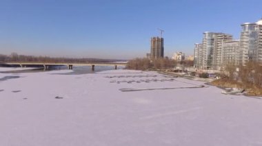 Kiev. Ukrayna. Dinyeper Nehri kış köprüden. Şehri kuşbakışı, gün batımı Lonza ile yayılır. Kiev şehir Dinyeper Nehri üzerinde olduğunu. Kiev batımında Dnieper Nehri üzerinde uçan. Daire binaların çatıları 