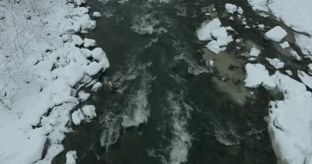 Montanhas no inverno. Voo sobre a paisagem de inverno das montanhas. Inverno nevado nas montanhas. Dia de inverno nublado. Paisagem de montanha da vista de um pássaro . — Vídeo de Stock