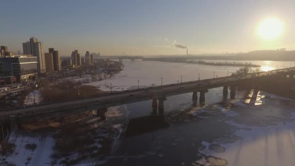 Kiev. Ukraine. The bridge across the Dnieper River Winter. Span over the city with a bird's-eye view at sunset Lonza. The city of Kiev is on the Dnieper River. Flying in Kiev on the Dnieper river at sunset. The roofs of apartment buildings — Stock Video