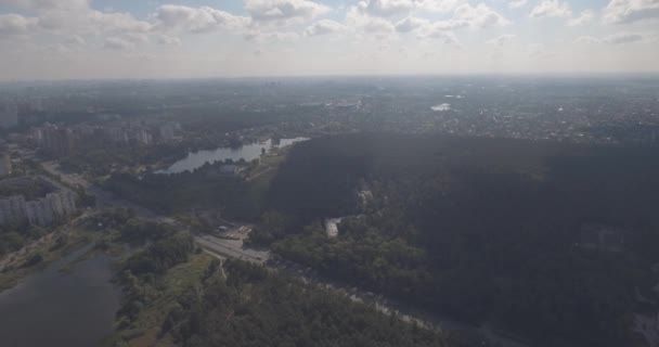 Indagine aerea: Kiev-Akademgorodok. Paesaggio urbano dall'alto. Paesaggio forestale con vista lago e metropoli. un bellissimo lago ai margini della città. foresta verde con un paesaggio urbano lago . — Video Stock