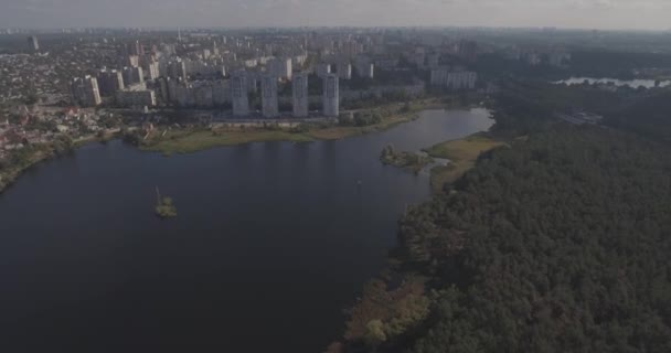 Flygfotografering: Kiev-Akademgorodok. stadsbild från luften. Skogslandskap med utsikt över sjön och metropolis. en vacker sjö i utkanten av staden. Grön skog med en sjön urbana landskap. — Stockvideo