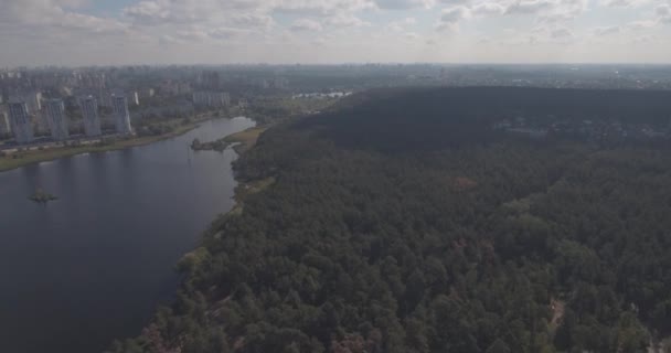 Indagine aerea: Kiev-Akademgorodok. Paesaggio urbano dall'alto. Paesaggio forestale con vista lago e metropoli. un bellissimo lago ai margini della città. foresta verde con un paesaggio urbano lago . — Video Stock