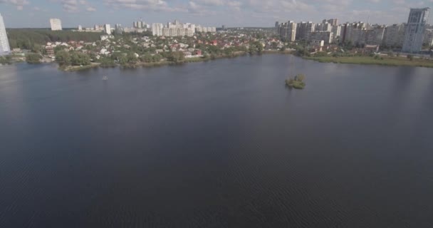 Indagine aerea: Kiev-Akademgorodok. Paesaggio urbano dall'alto. Paesaggio forestale con vista lago e metropoli. un bellissimo lago ai margini della città. foresta verde con un paesaggio urbano lago . — Video Stock