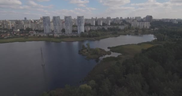 Estudio aéreo: Kiev-Akademgorodok. paisaje urbano desde el aire. Paisaje forestal con vistas al lago y a la metrópolis. un hermoso lago en el borde de la ciudad. bosque verde con un paisaje urbano lago . — Vídeos de Stock