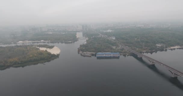 Aérea. Puente del metro de Kiev en tiempo nublado. Puente arqueado que pasa a través del río Dnieper la orilla izquierda. Niebla sobre el río y el puente. Hermoso paisaje urbano con vistas al río y al puente . — Vídeos de Stock