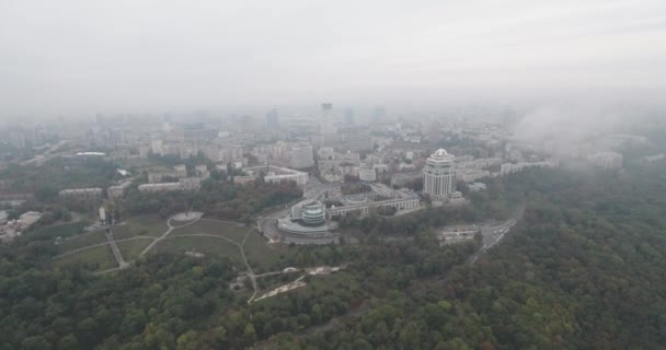 Εναέρια έρευνα. Κίεβο-πάρκο Αιώνιας Δόξας με θέα στην πόλη. Φθινοπωρινό τοπίο, πάρκο και μια μεγάλη μητρόπολη στην ομίχλη. Δέντρα από κίτρινα και κόκκινα άνθη. Πολυώροφα σπίτια στην ομίχλη. — Αρχείο Βίντεο
