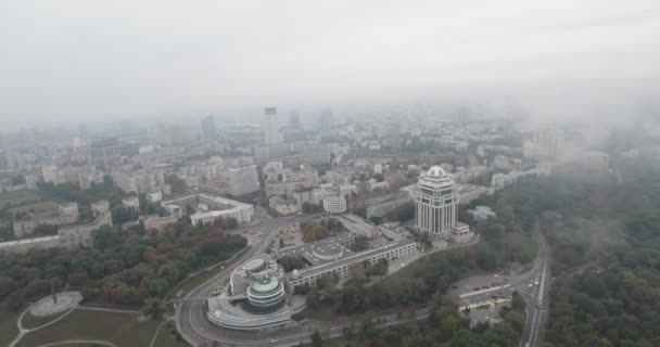 Flygfotografering. Kiev-park av evig härlighet med utsikt över staden. Hösten stadsbilden, park och en stor metropol i dimman. Träd av gula och röda blommor. Multi-storey husen i dimman. — Stockvideo