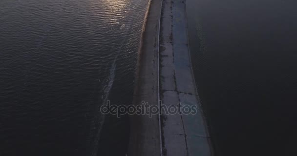 Аэросъемка. Киевское море, маяк, стоящий на реке Днепр 15. Сентябрь 2017. восход солнца над рекой. Волнолом с маяком стоит на воде и наполняет город волнами . — стоковое видео
