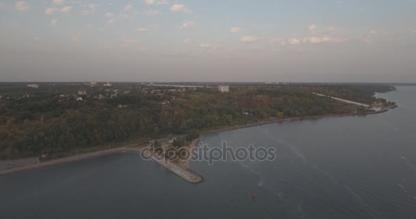 Luchtfoto enquête. De Kiev Sea, een vuurtoren aan de rivier de Dnjepr op 15 staan. September 2017. zonsopgang boven de rivier. De wavebreaker met een baken staat op het water en de stad vult met golven. — Stockvideo