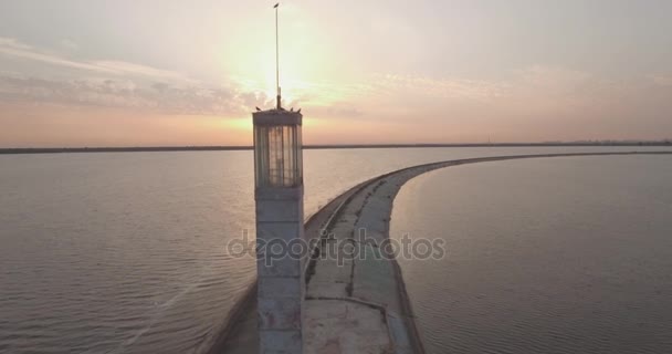 Luchtfoto enquête. De Kiev Sea, een vuurtoren aan de rivier de Dnjepr op 15 staan. September 2017. zonsopgang boven de rivier. De wavebreaker met een baken staat op het water en de stad vult met golven. — Stockvideo