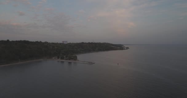 Luchtfoto enquête. De Kiev Sea, een vuurtoren aan de rivier de Dnjepr op 15 staan. September 2017. zonsopgang boven de rivier. De wavebreaker met een baken staat op het water en de stad vult met golven. — Stockvideo