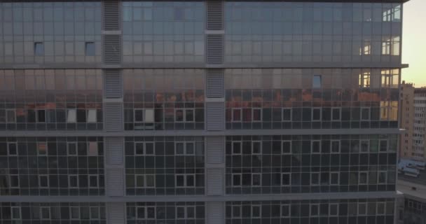 Luchtfoto onderzoek de stad van Kiev-linkeroever, een glazen gebouw bij dageraad. 27. September 2017. in de ramen van het kantoorgebouw een weerspiegeling van de zonsopgang buiten de horizon. stedelijk landschap. — Stockvideo