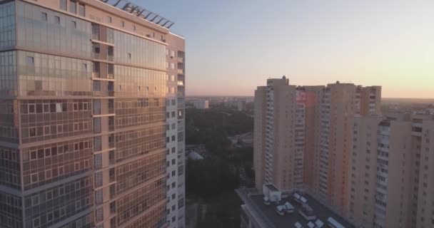 Luftaufnahme der Stadt Kiev-linkes Ufer, ein gläsernes Gebäude im Morgengrauen. 27. september 2017. in den fenstern des bürogebäudes spiegelt sich der sonnenaufgang jenseits des horizonts. Stadtlandschaft. — Stockvideo