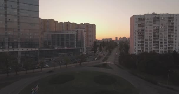 Levantamento aéreo a cidade de Kiev-margem esquerda, um edifício de vidro ao amanhecer. 27 anos. Setembro 2017. nas janelas do prédio de escritórios um reflexo do nascer do sol de além do horizonte. paisagem urbana . — Vídeo de Stock