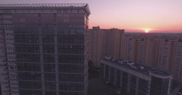 Luftaufnahme der Stadt Kiev-linkes Ufer, ein gläsernes Gebäude im Morgengrauen. 27. september 2017. in den fenstern des bürogebäudes spiegelt sich der sonnenaufgang jenseits des horizonts. Stadtlandschaft. — Stockvideo