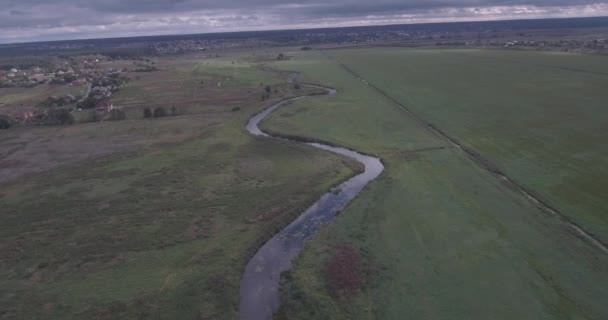 Letecký průzkum. malá řeka prochází zelené pole. Krásná louka s výhledem na řeku z ptačí perspektivy. letní den, stíny mraků leží na hřišti. — Stock video