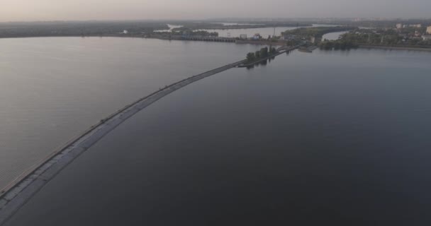 Aerial survey. The Kiev Sea, a lighthouse standing on the river Dnieper on 15. September 2017. sunrise over the river. The wavebreaker with a beacon stands on the water and fills the city with waves. — Stock Video