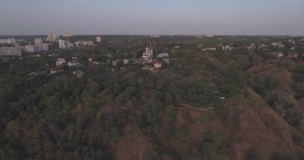 Inspección aérea. ciudad de Vyshgorod-iglesia en la montaña cerca del río Dniéper. amanecer en el río. una hermosa iglesia al amanecer. una pequeña iglesia se encuentra en la montaña al amanecer del día . — Vídeos de Stock