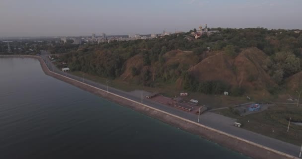 Letecký průzkum. město Vyšhorod-kostel na hoře nedaleko řeky Dněpru. východ slunce na řece. krásný kostel na východ slunce. malý kostel stojí na hoře na úsvitu dne. — Stock video