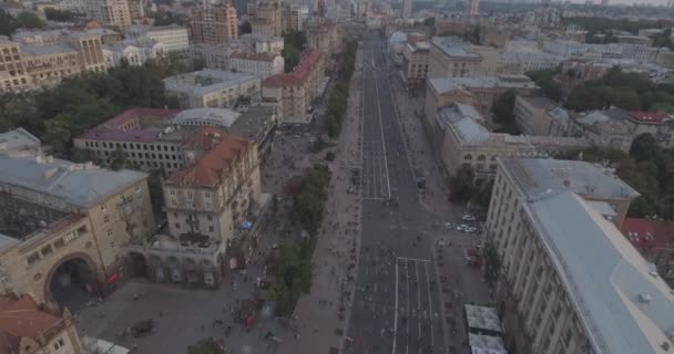 Aerial survey. Kiev-Independence Square 25. August 2017. There are crowds of people walking along the central street of Khreschyatik on a wilder day. sunset over the houses. people rest, they go to look at the performance of different groups. — Stock Video
