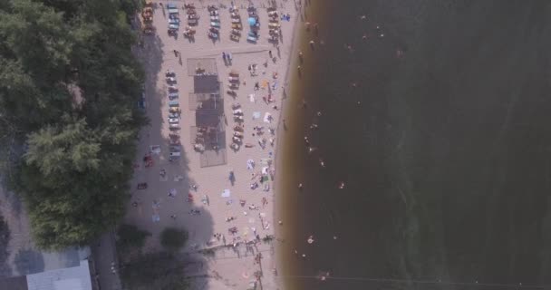 Aerial of the beach. summer sunny day, people are sunbathing on a yellow squeak on the bank of the Dnieper river city of Kiev. day off, vacation on the beach. a large number of tourists swim. — Stock Video
