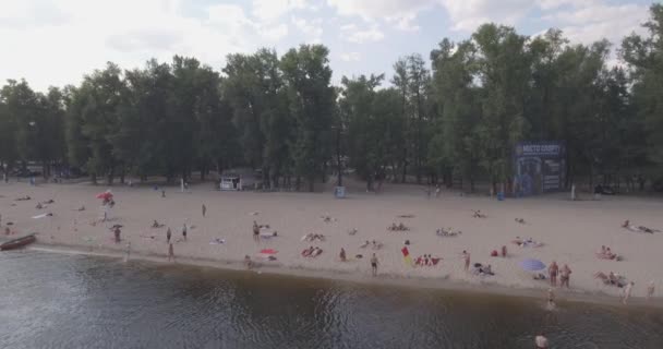 Aerea della spiaggia. estate giornata di sole, la gente sta prendendo il sole su un cigolio giallo sulla riva della città del fiume Dnieper di Kiev. giorno libero, vacanza sulla spiaggia. un gran numero di turisti nuotare . — Video Stock