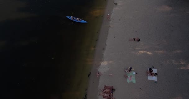 Antenne des Strandes. An einem sonnigen Sommertag sonnen sich die Menschen auf einem gelben Quietschen am Ufer der Dnjepr-Stadt Kiew. Ruhetag, Urlaub am Strand. Eine große Zahl von Touristen schwimmt. — Stockvideo